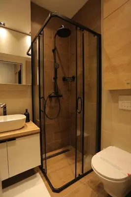 a bathroom with a shower with a toilet and a sink at Bonanza Apartments in Niš
