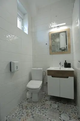 a white bathroom with a toilet and a sink at Bonanza Apartments in Niš