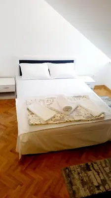 a bedroom with a bed with white sheets and white pillows at A&A in Vrnjačka Banja