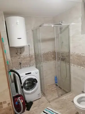 a bathroom with a washing machine and a shower at APARTMANI CEPERKOVIC in Vrnjačka Banja