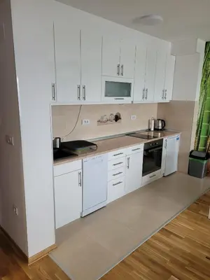 a kitchen with white cabinets and white appliances at APARTMANI CEPERKOVIC in Vrnjačka Banja