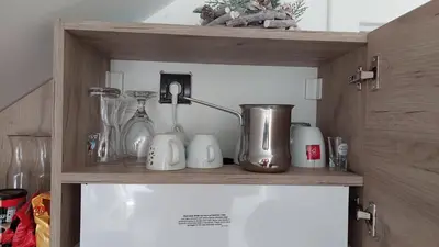 a shelf with various glass items on it at Ctrl Alt Del Apartment S76 in Kopaonik