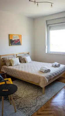 a large bed in a room with a window at Dvosoban stan u strogom centru in Kruševac