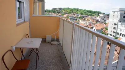 a balcony with a table and a view of a city at Dvosoban stan u strogom centru in Kruševac