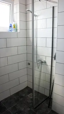 a shower with a glass door in a bathroom at Dvosoban stan u strogom centru in Kruševac