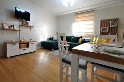 a living room with a couch and a table with chairs at Apartman Antic 1 in Vrnjačka Banja