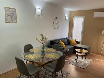 a living room with a glass table and a couch at Apartman - 411 in Vrnjačka Banja