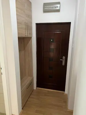 a hallway with a brown door and a closet at Apartman - 411 in Vrnjačka Banja