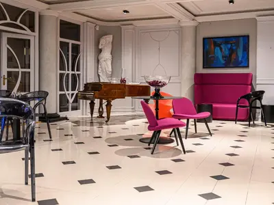 a living room with a piano and pink chairs at ArtLoft Garni Hotel in Niš