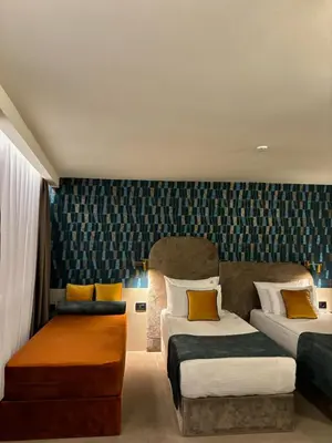 a hotel room with two beds and a couch at ArtLoft Garni Hotel in Niš