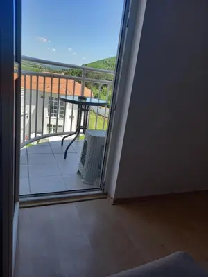 a room with a balcony with a table and a view at Smeštaj Voli - Borići studio-apartman, Sokobanja in Soko Banja