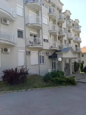 a large apartment building with white balconies and a street at Smeštaj Voli - Borići studio-apartman, Sokobanja in Soko Banja