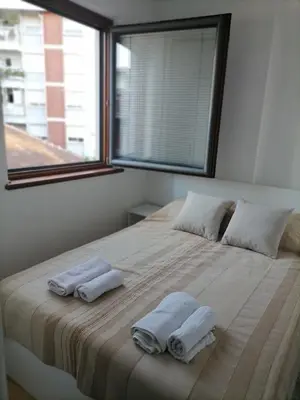 a bedroom with two towels on a bed with a window at Apartman Boki in Vrnjačka Banja