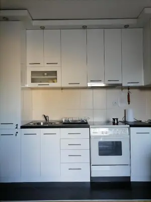 a kitchen with white cabinets and a sink and a stove at Apartman Boki in Vrnjačka Banja