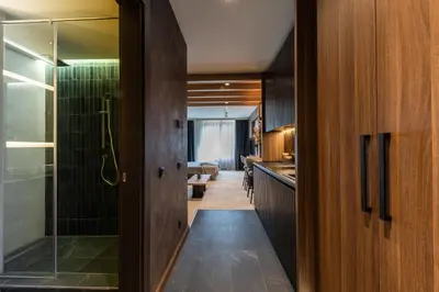 a bathroom with a walk in shower and a glass door at Aparthotel Woodside by Anaya in Kopaonik