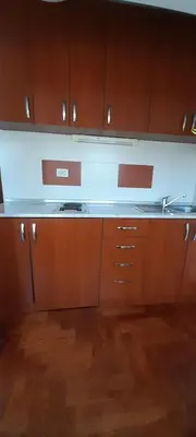 a kitchen with wooden cabinets and a white counter top at Apartman President in Vrnjačka Banja