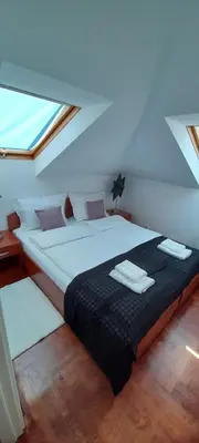 a bedroom with a large bed with two towels on it at Apartman President in Vrnjačka Banja