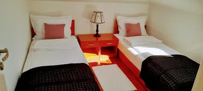 a small room with two beds and a table with a lamp at Apartman President in Vrnjačka Banja