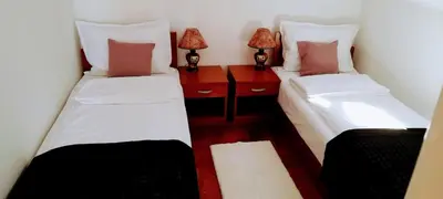a room with two beds and a desk with two lamps at Apartman President in Vrnjačka Banja