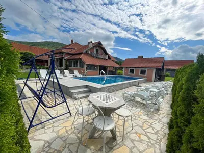 a patio with a swing and a swimming pool at Djokić 2 sa bazenom in Soko Banja