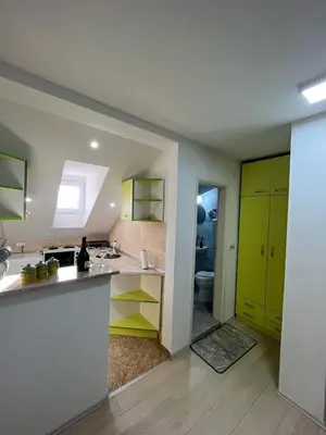 a kitchen with yellow and green cabinets and a bathroom at Djokić 2 sa bazenom in Soko Banja