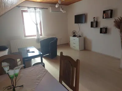 a living room with a table and a dining room at Djokić 2 sa bazenom in Soko Banja