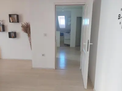 a hallway with a door open to a living room at Djokić 2 sa bazenom in Soko Banja