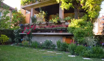 a house with a balcony with flowers and plants at Apartman Wisteria in Vranje