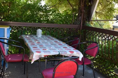 a table and chairs sitting on a fence with a table at Apartman Wisteria in Vranje