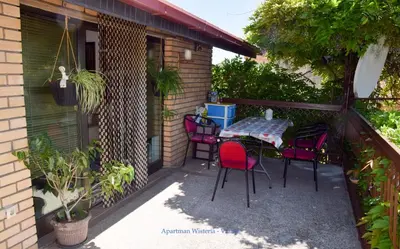 a patio with a table and chairs on a balcony at Apartman Wisteria in Vranje