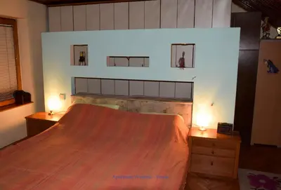 a bedroom with a large bed and two night stands at Apartman Wisteria in Vranje