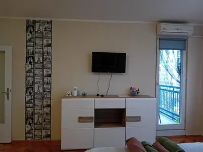 a living room with a tv on a wall at Apartman A-1 in Zaječar