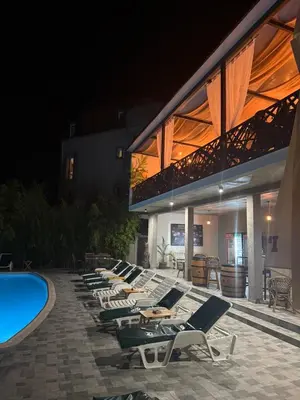 a row of lounge chairs next to a swimming pool at City view & pool apartment in Niš