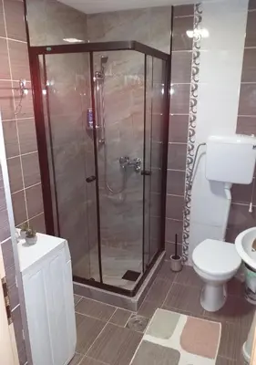 a bathroom with a shower and a toilet at City view & pool apartment in Niš