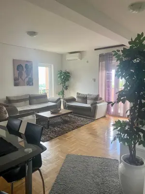 a living room with a couch and a table at City view & pool apartment in Niš