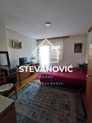 a living room with a bed and a window at Stevanovic Smestaj in Vrnjci