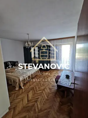 a bedroom with a bed and a wooden floor at Stevanovic Smestaj in Vrnjci