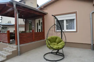 a green chair sitting on the porch of a house at Milivojevic in Soko Banja