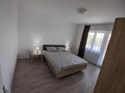 a white bedroom with a bed and a window at Apartman IKA Sokobanja in Soko Banja
