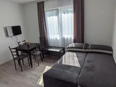 a bedroom with a bed and a table and a dining room at Apartman IKA Sokobanja in Soko Banja