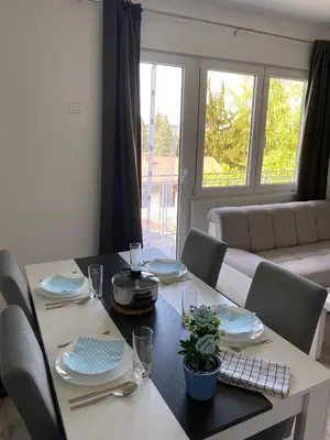 a dining room with a table with chairs and a dining room at Apartman Jorgos in Soko Banja