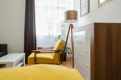 a living room with a yellow chair and a lamp at Sleep Hostel in Niš