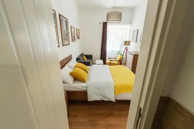 a bedroom with a bed with a yellow blanket at Sleep Hostel in Niš
