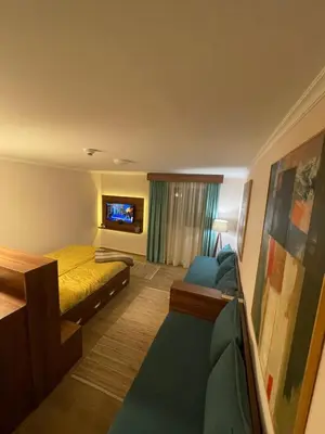 a hotel room with a bed and a couch and a tv at Dolce Vita in Kopaonik