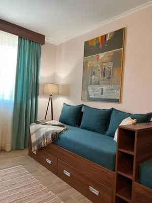 a bed with blue sheets in a room with a window at Dolce Vita in Kopaonik