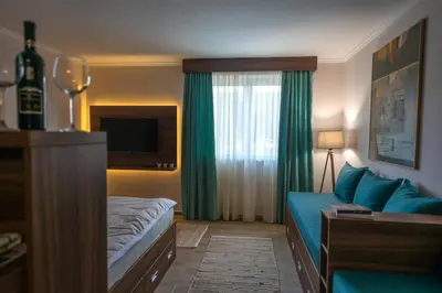 a hotel room with a blue couch and a window at Dolce Vita in Kopaonik