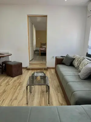 a living room with a couch and a glass coffee table at Apartman Zigic in Soko Banja