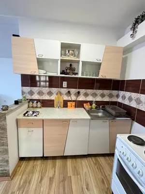 a kitchen with white and brown cabinets and a sink at Apartman Zigic in Soko Banja