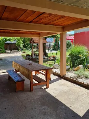a wooden picnic table and a bench under a pavilion at Apartman Zigic in Soko Banja
