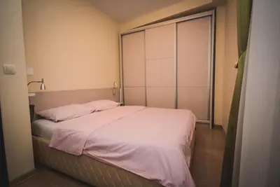 a small bedroom with a bed with pink sheets at Apartment Ilunion I in Vrnjačka Banja